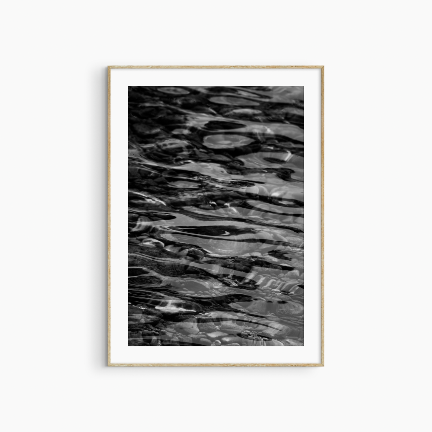 Dark water over pebbles photography print, black and white abstract wall art, coastal ripple print
