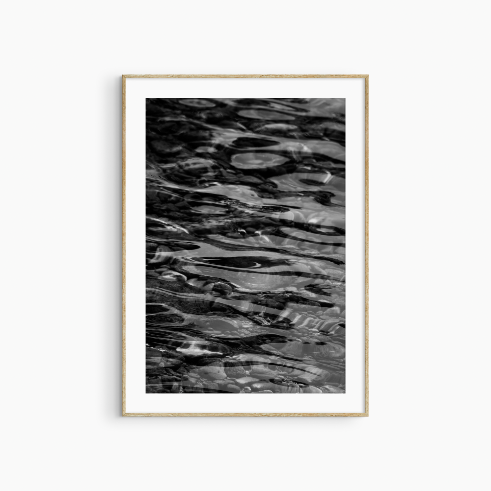 Dark water over pebbles photography print, black and white abstract wall art, coastal ripple print