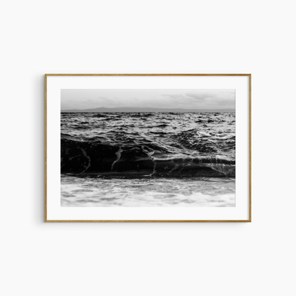 Dark rolling wave and island photography print, black and white coastal wall art, moody seascape print