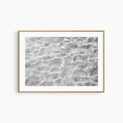 Shallow water over pebble shore photography print, black and white abstract wall art, coastal light print